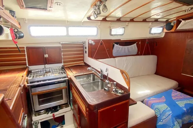 Slide: The Image of 1975 Whitby 42 Ketch interior with kitchen, sink, and seating area. - 20