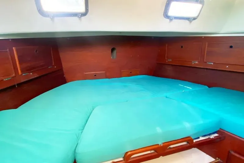 Slide: The Image of Interior cabin of 1975 Whitby 42 Ketch with teal cushions and wooden storage. - 22