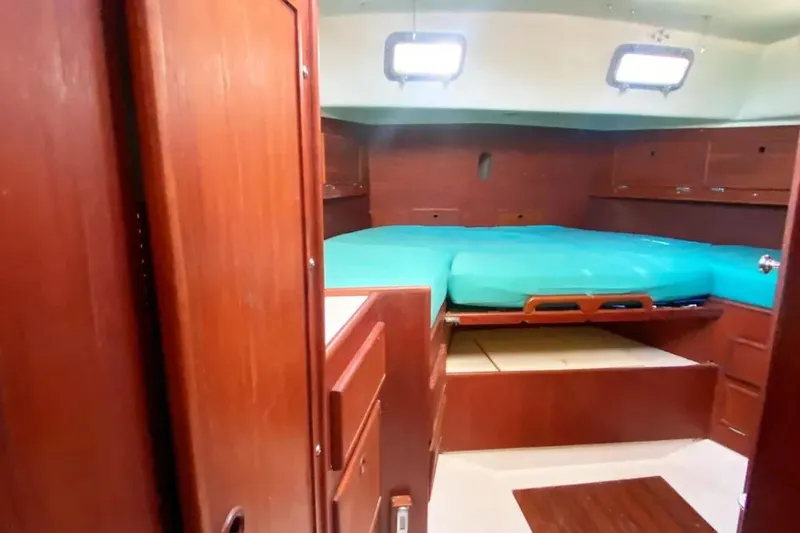 Slide: The Image of Interior cabin of 1975 Whitby 42 Ketch with wooden finish and teal bedding. - 23