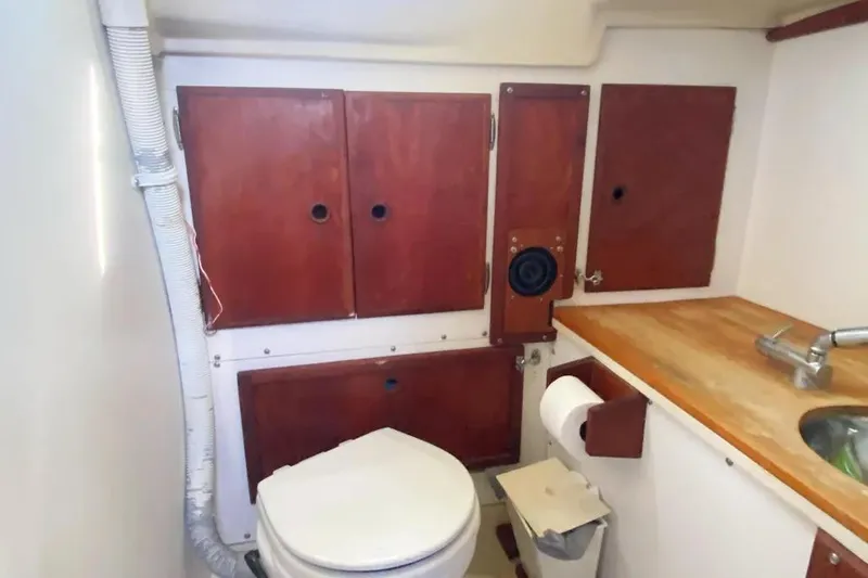 Slide: The Image of 1975 Whitby 42 Ketch bathroom with wooden cabinets, sink, and toilet. - 26