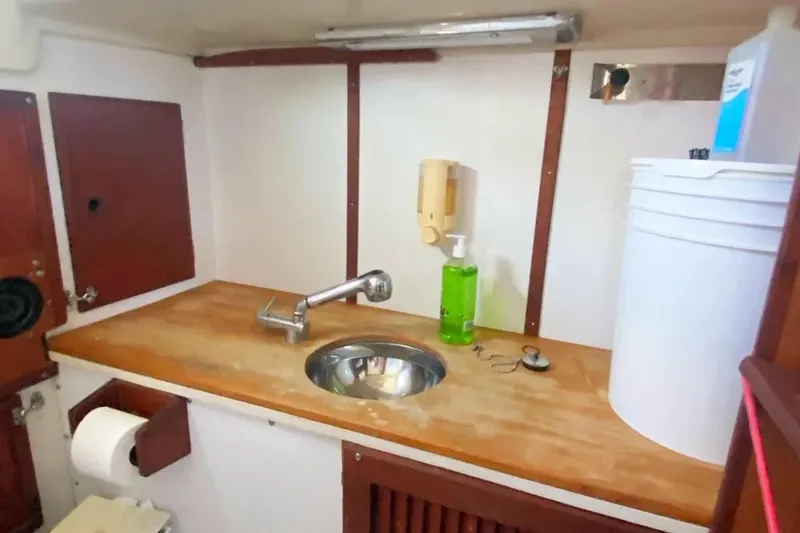 Slide: The Image of 1975 Whitby 42 Ketch interior with wooden countertop and sink in the galley area. - 27