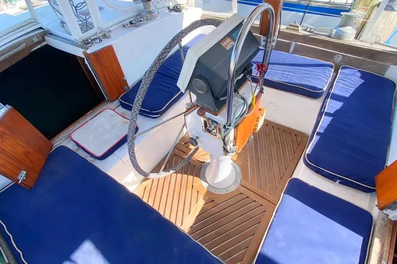 Slide: The Image of Cockpit of 1975 Whitby 42 Ketch with blue cushions and wooden flooring. - 3