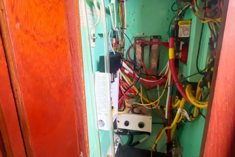 Slide: The Image of Electrical wiring inside a 1975 Whitby 42 Ketch sailboat, featuring colorful cables and components. - 37