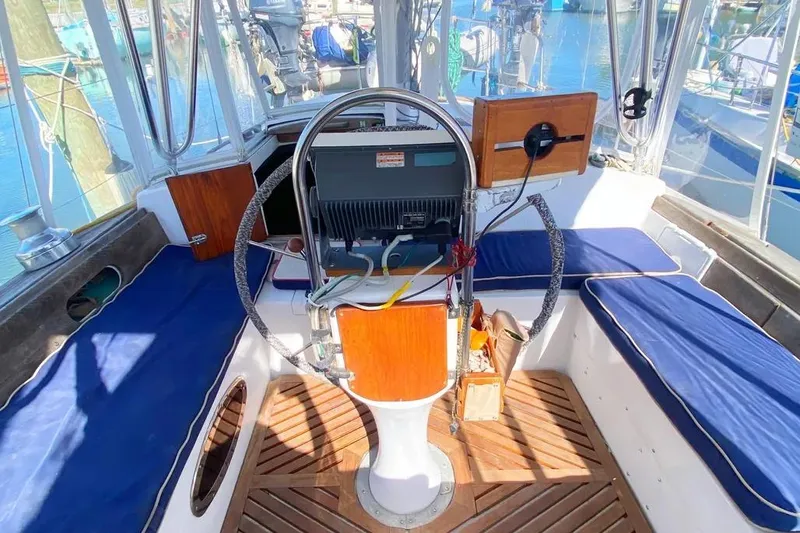 Slide: The Image of Cockpit of 1975 Whitby 42 Ketch with blue cushions and wooden accents. - 4