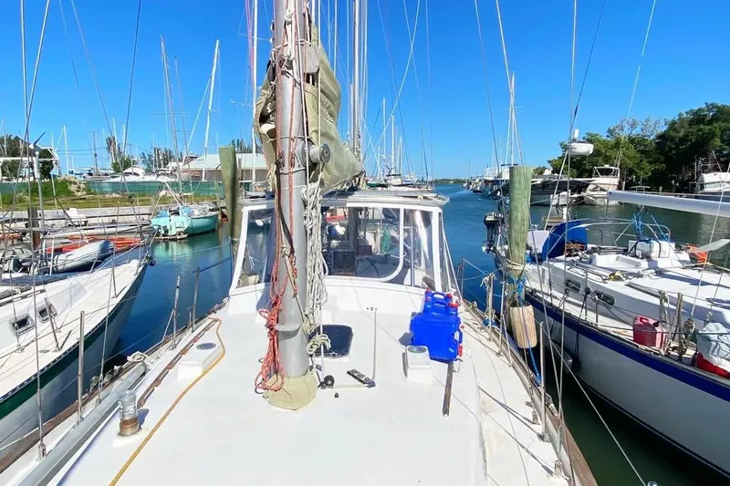Slide: The Image of 1975 Whitby 42 Ketch sailboat docked in a marina under clear blue skies. - 6