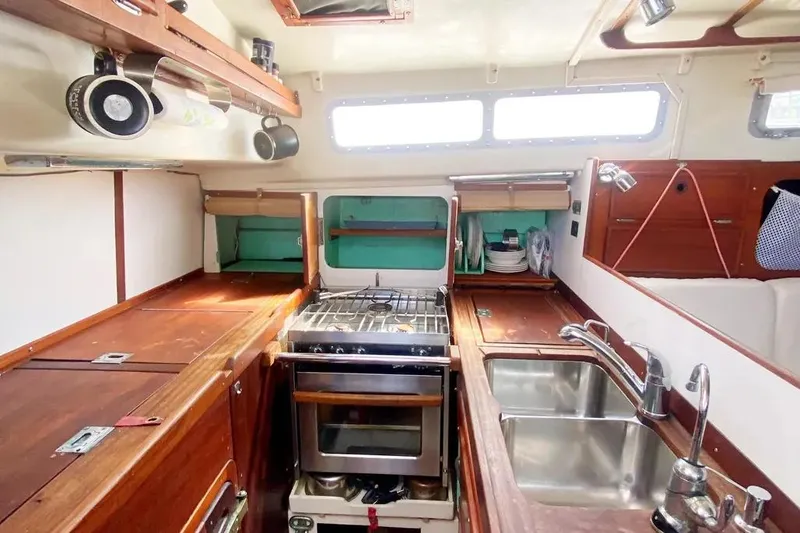 Slide: The Image of 1975 Whitby 42 Ketch kitchen with stove, sink, and wooden cabinetry. - 9