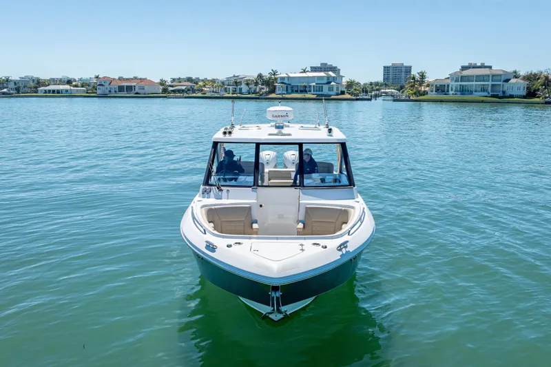 Slide: The Image of 2019 Everglades 340 Dual Console boat on calm water near luxury waterfront homes. - 10