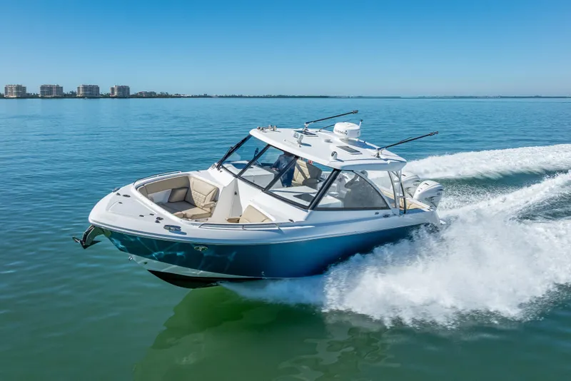 Slide: The Image of 2019 Everglades 340 Dual Console boat cruising on clear blue water. - 12