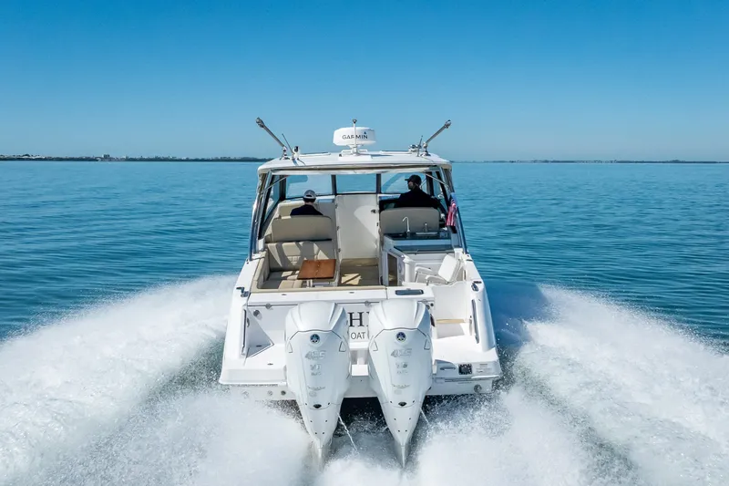 Slide: The Image of 2019 Everglades 340 Dual Console boat cruising on open water, rear view. - 15
