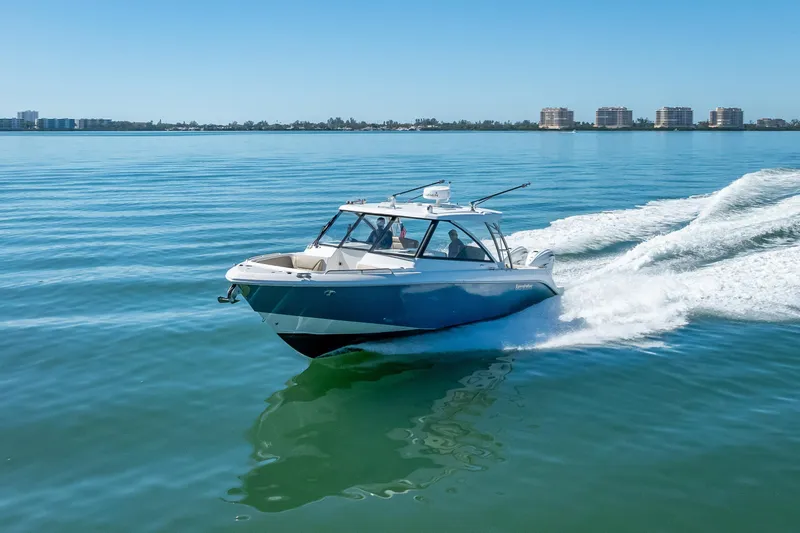 Slide: The Image of 2019 Everglades 340 Dual Console boat cruising on calm blue waters. - 17