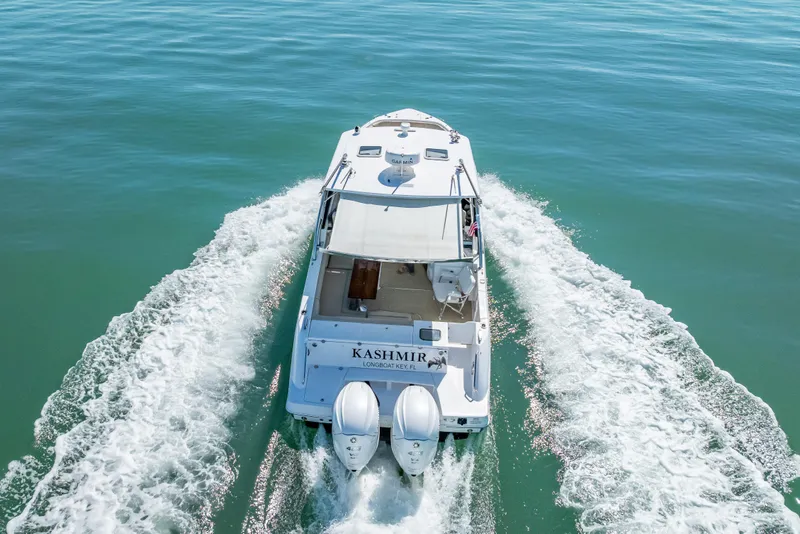 Slide: The Image of 2019 Everglades 340 Dual Console boat cruising on clear blue water. - 19