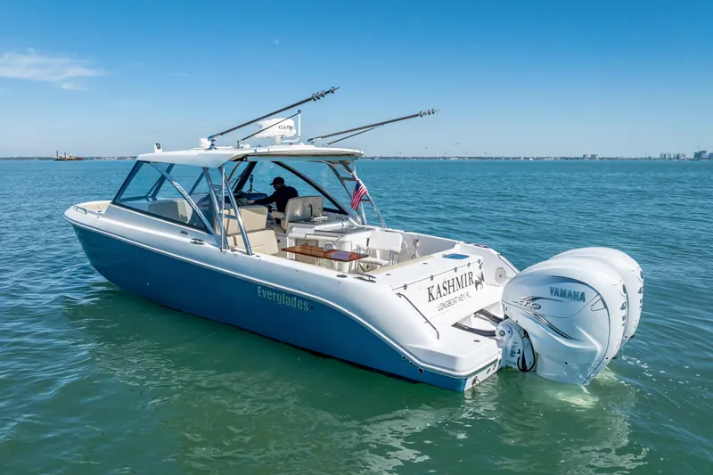 Slide: The Image of 2019 Everglades 340 Dual Console boat on open water, featuring twin Yamaha engines. - 2