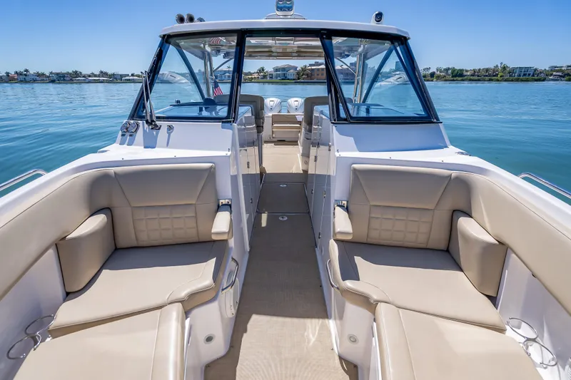 Slide: The Image of 2019 Everglades 340 Dual Console boat interior with beige seating on calm water. - 23