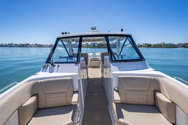 Slide: The Image of 2019 Everglades 340 Dual Console boat on calm water, featuring spacious seating and clear skies. - 24