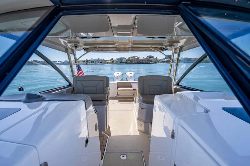 Slide: The Image of 2019 Everglades 340 Dual Console boat interior with lake view and American flag. - 25