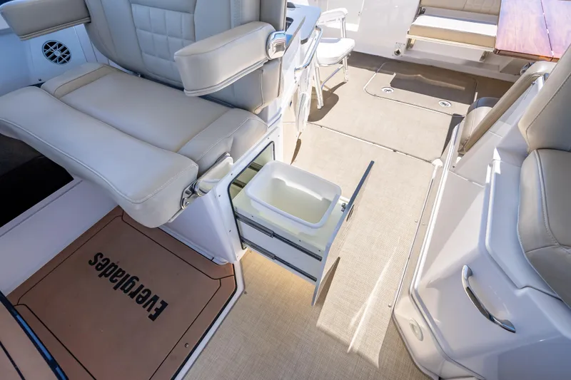 Slide: The Image of 2019 Everglades 340 Dual Console interior with seating and storage drawer open. - 39