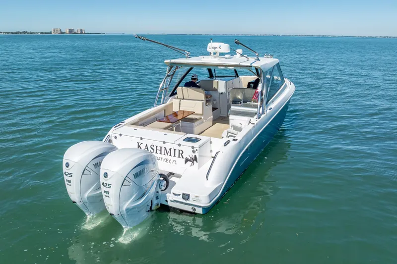 Slide: The Image of 2019 Everglades 340 Dual Console boat on water, featuring twin Yamaha 425 engines. - 4