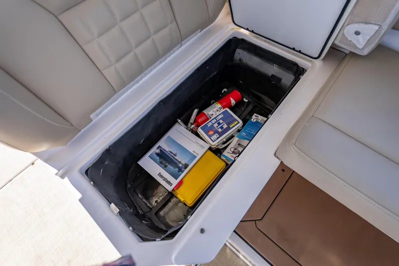 Slide: The Image of Storage compartment in 2019 Everglades 340 Dual Console boat with safety equipment and manuals. - 40
