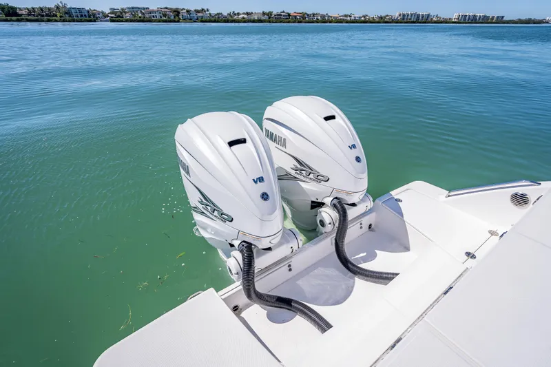 Slide: The Image of Twin Yamaha V8 engines on a 2019 Everglades 340 Dual Console boat, docked on calm water. - 45