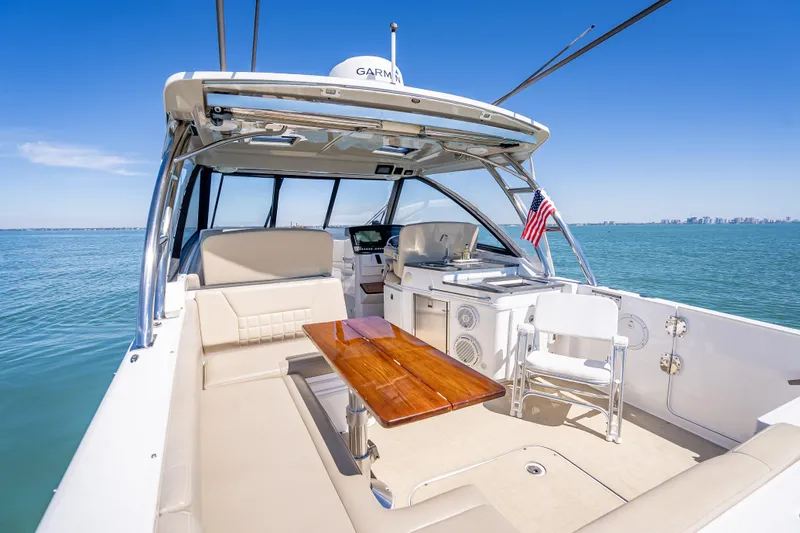 Slide: The Image of 2019 Everglades 340 Dual Console boat interior with seating, table, and ocean view. - 48