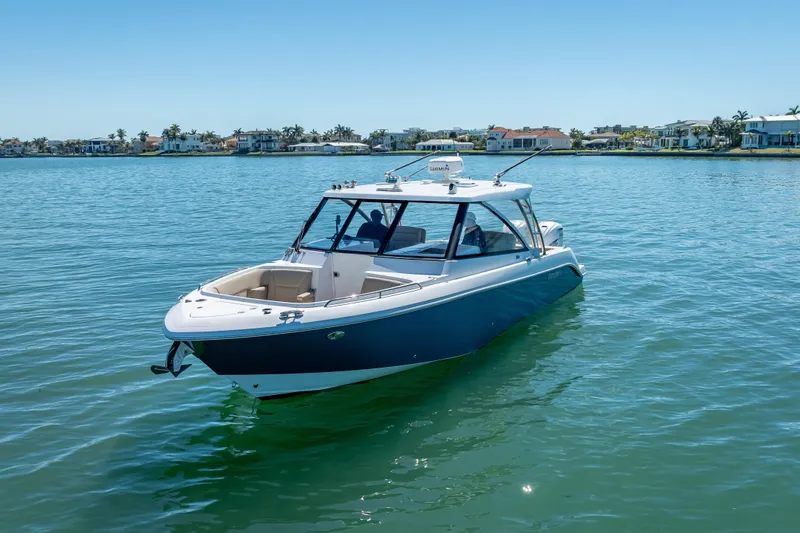Slide: The Image of 2019 Everglades 340 Dual Console boat on calm water, coastal homes in background. - 9