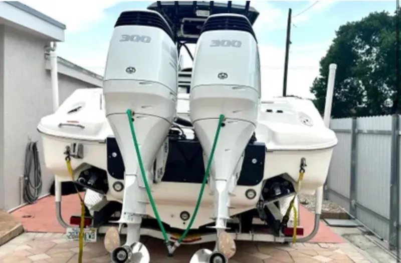 Slide: The Image of 2006 Wellcraft 32 CCF boat with dual 300 horsepower outboard engines, parked on a driveway. - 43