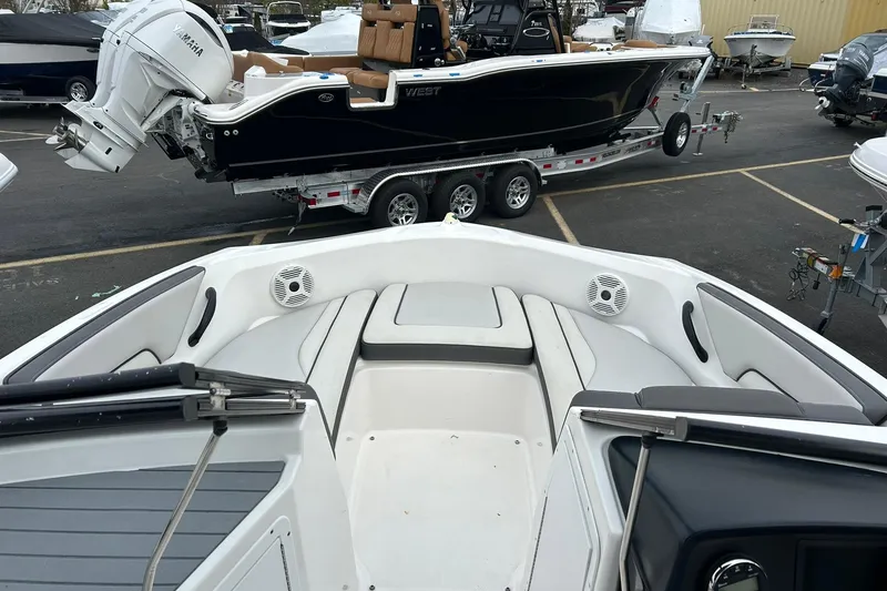 Slide: The Image of 2019 Yamaha Boats AR190 interior with seating, parked in a marina with other boats. - 12