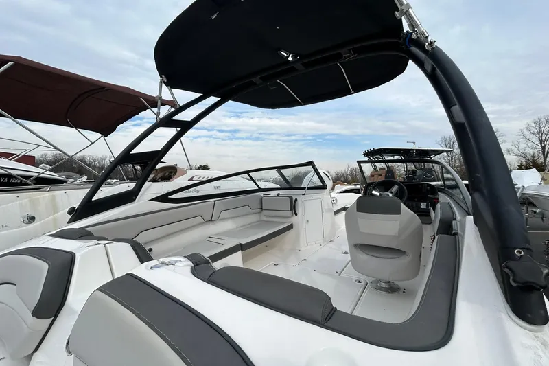 Slide: The Image of 2019 Yamaha Boats AR190 interior with seating and steering wheel, docked under cloudy sky. - 4