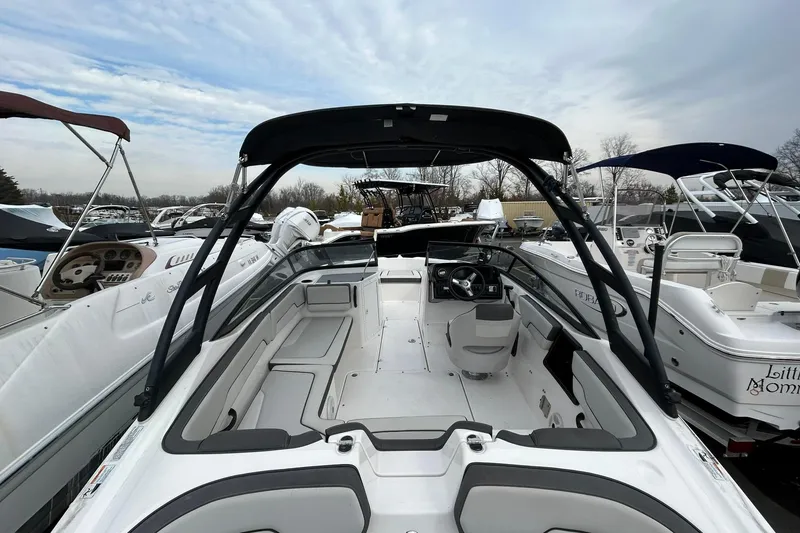 Slide: The Image of 2019 Yamaha Boats AR190, sleek interior view, surrounded by other boats in a marina. - 6