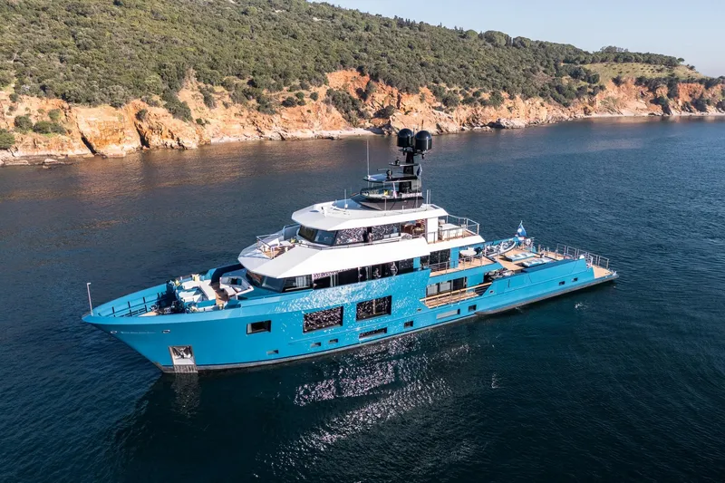 Slide: The Image of 2024 Dunya Yachts Explorer cruising on calm waters near a scenic coastline. - 2