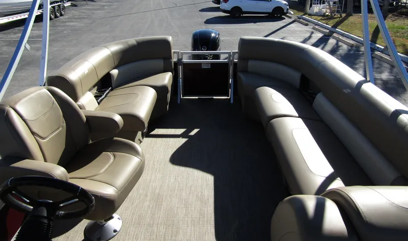 Slide: The Image of 2024 Starcraft LX 20 R pontoon boat interior with beige seating and steering wheel. - 17