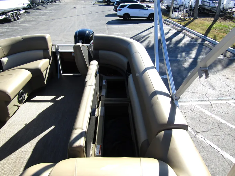 Slide: The Image of 2024 Starcraft LX 20 R pontoon boat interior with beige seating and storage compartments. - 19