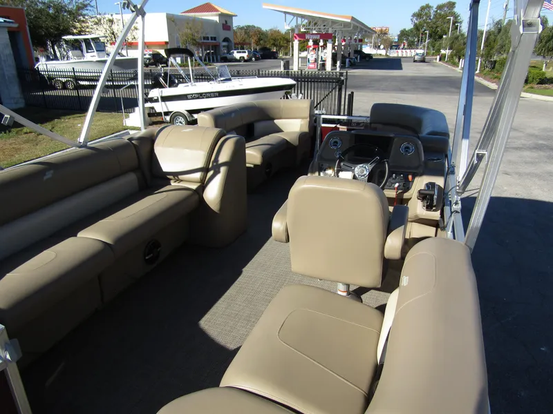 Slide: The Image of 2024 Starcraft LX 20 R pontoon boat interior with beige seating and steering console. - 24