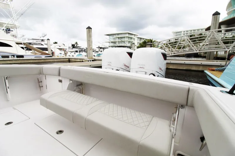 Slide: The Image of 2024 Jupiter 34 HFS boat with twin outboard engines docked at a marina. - 13