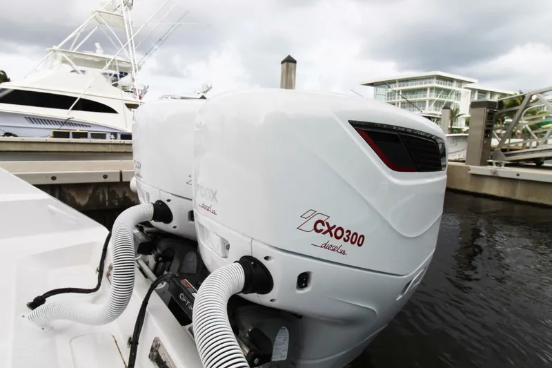 Slide: The Image of Twin CXO300 outboard engines on a 2024 Jupiter 34 HFS boat docked at a marina. - 15