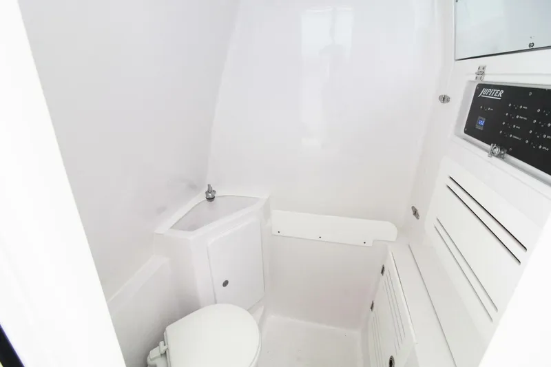 Slide: The Image of 2024 Jupiter 34 HFS boat interior bathroom with white fixtures and compact design. - 16