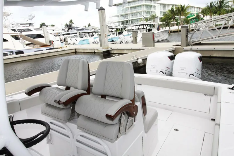 Slide: The Image of 2024 Jupiter 34 HFS boat interior with dual seats and twin outboard engines at marina. - 4