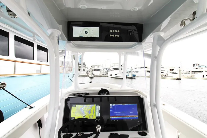 Slide: The Image of 2024 Jupiter 34 HFS boat dashboard with navigation screens at a marina. - 7