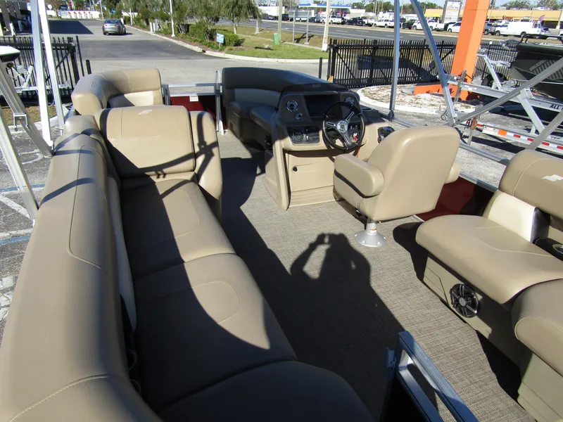 Slide: The Image of 2024 Starcraft LX 20 R pontoon boat interior with beige seating and steering console. - 23
