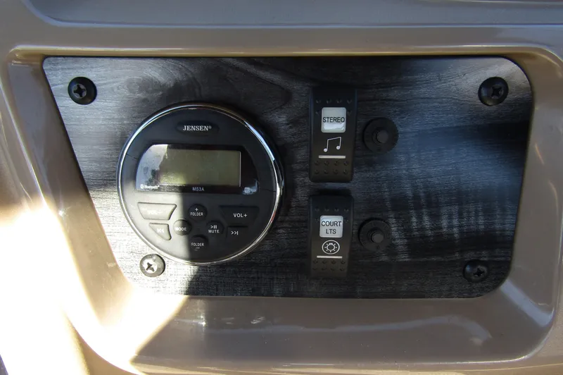 Slide: The Image of 2024 Starcraft LX 20 R control panel with stereo and court lights switches. - 14