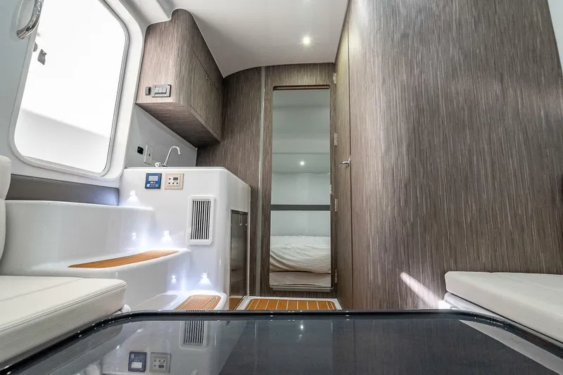 Slide: The Image of 2024 Yellowfin 54 Offshore interior cabin with modern design and wood accents. - 13