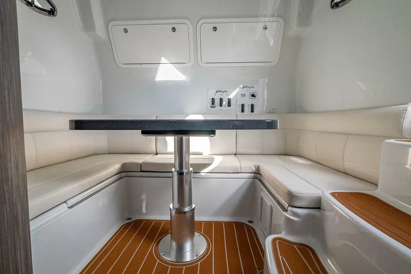 Slide: The Image of 2024 Yellowfin 54 Offshore interior with cushioned seating and sleek table design. - 29
