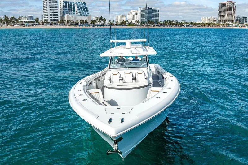 Slide: The Image of 2024 Yellowfin 54 Offshore boat cruising near a coastal city skyline. - 4