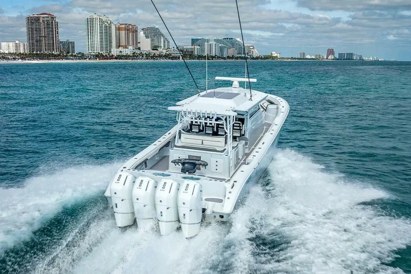 Slide: The Image of 2024 Yellowfin 54 Offshore boat cruising near city skyline on open water. - 9