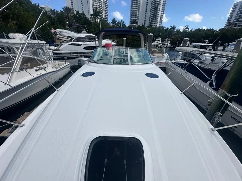 Slide: The Image of 2004 Sea Ray 340 Sundancer yacht docked at marina with surrounding boats and buildings. - 11