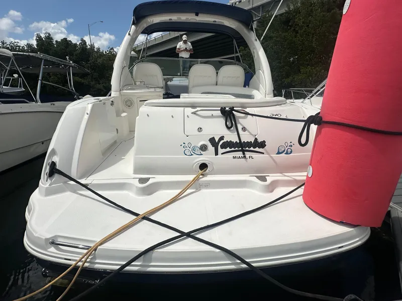 Slide: The Image of 2004 Sea Ray 340 Sundancer docked, featuring spacious seating and a red fender. - 12