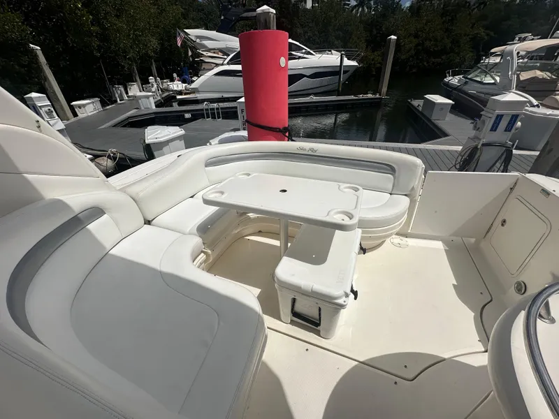 Slide: The Image of 2004 Sea Ray 340 Sundancer boat with white seating and table at marina. - 13