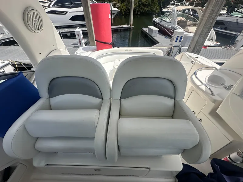 Slide: The Image of 2004 Sea Ray 340 Sundancer cockpit with plush seating and marina view. - 15