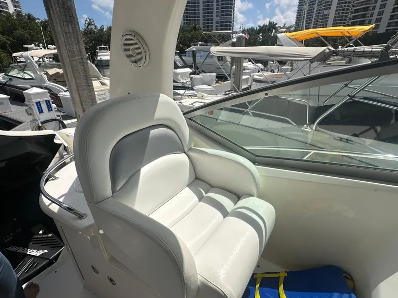 Slide: The Image of Captain's seat on 2004 Sea Ray 340 Sundancer, docked with other boats in background. - 19