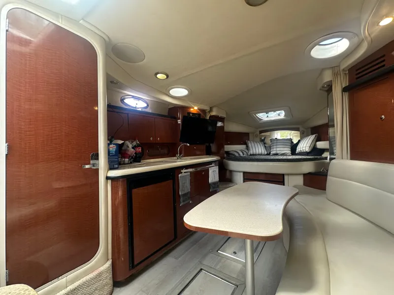 Slide: The Image of 2004 Sea Ray 340 Sundancer cabin interior with kitchenette, seating, and sleeping area. - 27